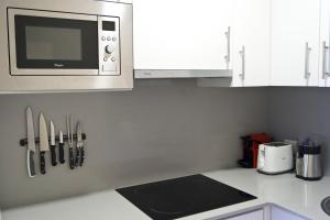 una cocina con microondas sobre una barra con cuchillos en Apartamento Premium Playa Altar 2, en Barreiros