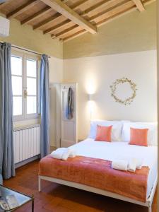 - une chambre avec un grand lit blanc et des oreillers orange dans l'établissement La Mezzina - Unique design and crafted lifestyle, à Florence