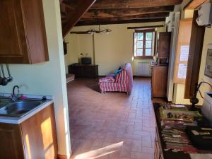 uma cozinha com um lavatório e uma sala de estar em bacciano casa vacanze em Poggio