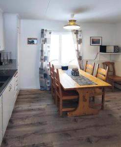 een keuken en eetkamer met een houten tafel en stoelen bij Holiday home - Semesterhus Solnedgång in Blattniksele