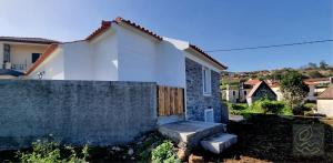 ein weißes Haus mit einem Holztor und einem Zaun in der Unterkunft My Little Home Cottage 2 Bedrooms - Soulful Stays in Porto Moniz
