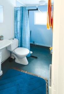 La salle de bains bleue est pourvue de toilettes et d'un lavabo. dans l'établissement Holiday home - Semesterhus Solnedgång, à Blattniksele
