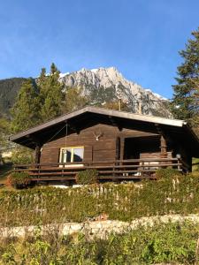 une cabane en rondins avec une montagne en arrière-plan dans l'établissement Tiroler Chalet mit toller Aussicht, à Nassereith