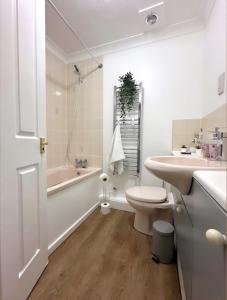 La salle de bains est pourvue de toilettes, d'un lavabo et d'une baignoire. dans l'établissement Md Stays, à Londres