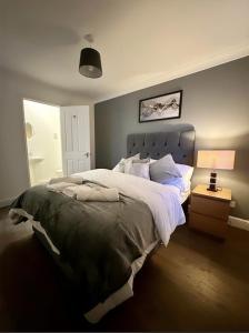 a bedroom with a large bed and a lamp at Md Stays in London