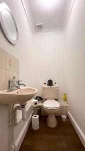 a bathroom with a sink and a toilet and a mirror at Md Stays in London
