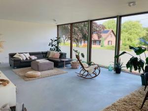 a living room with a couch and some plants at Sweet Valley View - Architectenwoning in Zutendaal
