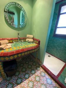een badkamer met een wastafel en een spiegel bij Chambre Emeraude, Riad 9 Couple only au village naturiste in Cap d'Agde
