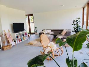 a living room with a couch and a tv at Sweet Valley View - Architectenwoning in Zutendaal