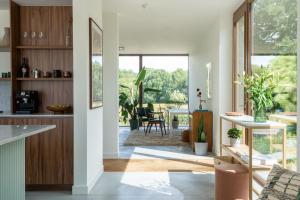 a kitchen and living room with a view of a patio at Sweet Valley View - Architectenwoning in Zutendaal