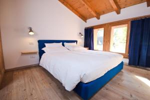 ein großes Bett mit blauem Kopfteil in einem Schlafzimmer in der Unterkunft Hotel Martinelli in Rontz-Klenz