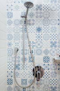 um chuveiro numa casa de banho com azulejos azuis e brancos em Капсульний готель Добрий sleep&eat em Dnipro