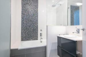 Un baño blanco con bañera y lavabo. en Luxury Muntaner Plaza, en Barcelona 12 fotos más