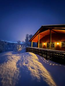 的住宿－Trivelig hytte i Senja.，夜晚雪中的一个小屋