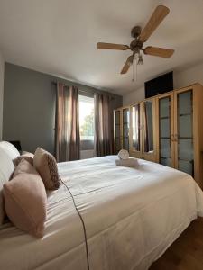 a bedroom with a large white bed with a ceiling fan at no.6 overnight stays in Hindlip