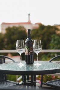 una botella de vino sentada en una mesa con dos copas de vino en Pension Štěpán, en Mikulov