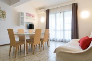 un soggiorno con tavolo da pranzo e sedie di Residence Oasi a Limone sul Garda
