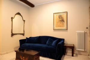 a living room with a blue couch and a mirror at Saint Charles Apartment in Bologna