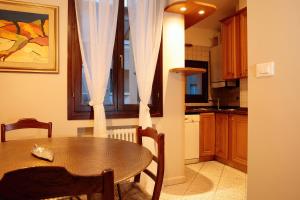 a kitchen with a wooden table and a dining room at Saint Charles Apartment in Bologna