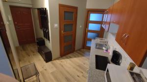 pusta kuchnia z drewnianą podłogą i drewnianymi drzwiami w obiekcie Apartament Warszawska we Włocławku