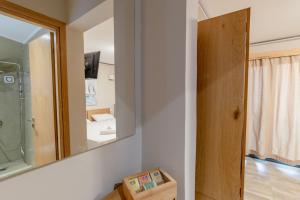 扎金索斯鎮的住宿－Zama Suites，浴室设有镜子、盥洗盆和卫生间