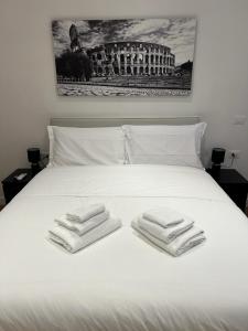 a white bed with two towels on top of it at Roma Mia in Trastevere in Rome
