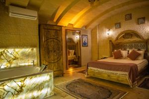 a bedroom with a bed and a tub in a room at Garden Suites Hotel Cappadocia in Göreme