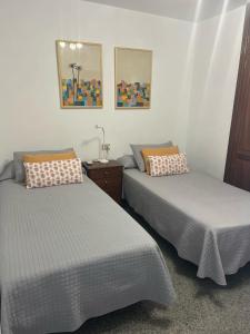 sypialnia z 2 łóżkami, stołem i zdjęciami w obiekcie Playa Chica apartment w Puerto del Carmen