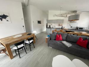 ein Wohnzimmer und eine Küche mit einem Sofa und einem Tisch in der Unterkunft Amt11 - Relax / family / home-office in Bad Wörishofen