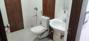 a bathroom with a toilet and a sink at Hotel Raj Mandir in Haridwār
