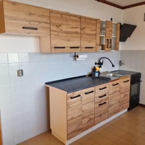 una cocina con armarios de madera y fregadero en WILLA MIŁA, en Stalowa Wola