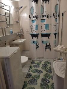 a bathroom with a shower curtain with a toilet and a sink at Sea Apart Velhontie in Kotka +41 photos