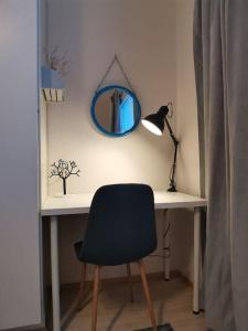 uma secretária com uma cadeira e um espelho na parede em Sea Apart Velhontie em Kotka