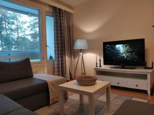 a living room with a couch and a tv at Sea Apart Velhontie in Kotka