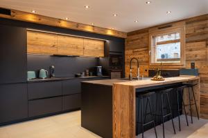 a kitchen with black and wooden walls and a counter at Chalet Mayen, luxueux et intimiste in Ban-sur-Meurthe-Clefcy