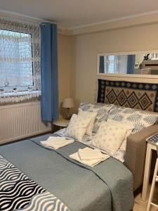 a bedroom with a large bed with blue curtains at Traper Apartamenty in Sopot