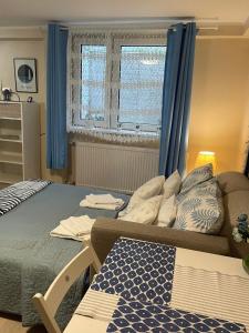 a bedroom with a bed with blue curtains and a couch at Traper Apartamenty in Sopot
