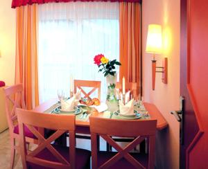 a dining room table with chairs and a vase of flowers at Landhotel Zenzerwirt in Hippach +22 photos