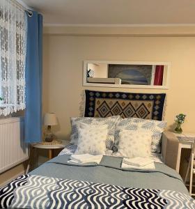 ソポトにあるTraper Apartamentyのベッドルーム1室(青いカーテン付きの大型ベッド1台付)