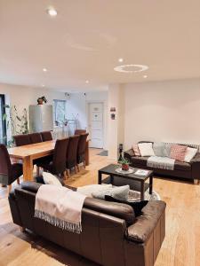 a living room with a couch and a table and chairs at En-suites and Rooms Near Wembley Stadium in London