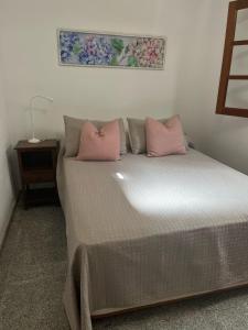 a bed with two pink pillows on it in a room at Playa Chica apartment in Puerto del Carmen