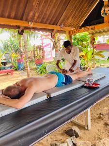 - un homme sur une table de massage avec un masseur dans l'établissement Ramya Ru Beach Home, à Galle