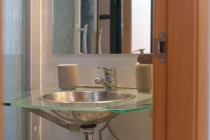 um lavatório de casa de banho com uma bancada de vidro em Apartamento junto a las Setas de Sevilla em Sevilha