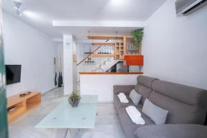 uma sala de estar com um sofá e uma mesa em Apartamento junto a las Setas de Sevilla em Sevilha