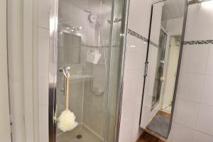 La salle de bains est pourvue d'une douche avec une porte en verre. dans l'établissement Le Nid de l'Yvette, à Chilly-Mazarin