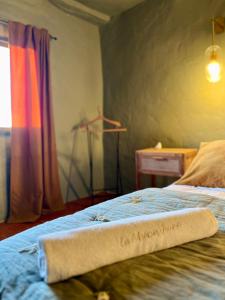 Un dormitorio con una cama con una toalla. en La Maison Jaune, une expérience inoubliable, en Villes-sur-Auzon