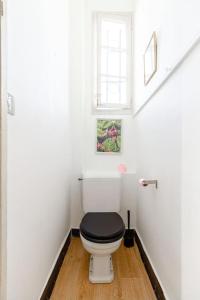 ein weißes Bad mit einem WC und einem schwarzen Sitz in der Unterkunft La grande maison-Toulouse Garonne-parking/jardin in Toulouse