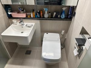 a small bathroom with a toilet and a sink at Byeollae Station ipark Suite in Namyangju
