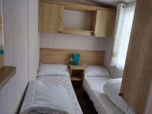 una camera con due letti e una scrivania di 208 Holiday Resort Unity 3 bed Passes included a Brean