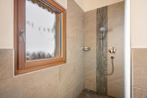 a bathroom with a shower with a window at Seppnerhof Ferienwohnung Edelweiss in Pfelders